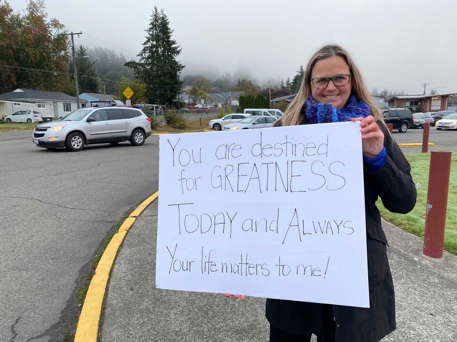Dr. Jennifer Scalici is pictured holding a sign in front of W.F. West High School in this photograph provided by the Chehalis School District last week.